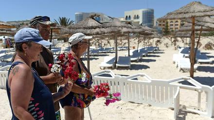 Geschockt und ungläubig. Touristen am Tatort des blutigen Geschehens am Strand von Sousse.