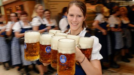 Eine Kellnerin trägt am 20.09.2014 am Eröffnungstag des Oktoberfestes in München Maßkrüge mit Bier. Quasi traditionell wird die Maß jedes Jahr teurer.