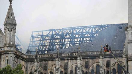 Feuerwehrleute bei den Löscharbeiten in der Basilika "Saint Donatien" in Nantes, Frankreich, am Montagvormittag.