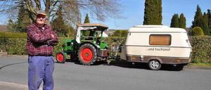 Winfried Langner, auch bekannt als "Trecker-Willi", steht in Lauenförde (Niedersachsen) an seinem Trecker mit Wohnanhänger.
