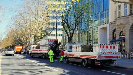 Eine Baustelle verschwindet. Arbeiter bringen Absperrungen vor dem Haus Cumberland und den Bauten am Kurfürstendamm 195 weg.