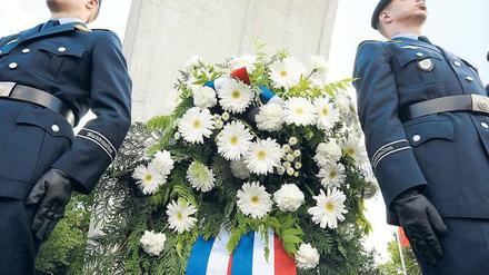 Zwei US-amerikanische Soldaten stehen am Denkmal für die Berliner Luftbrücke stramm.