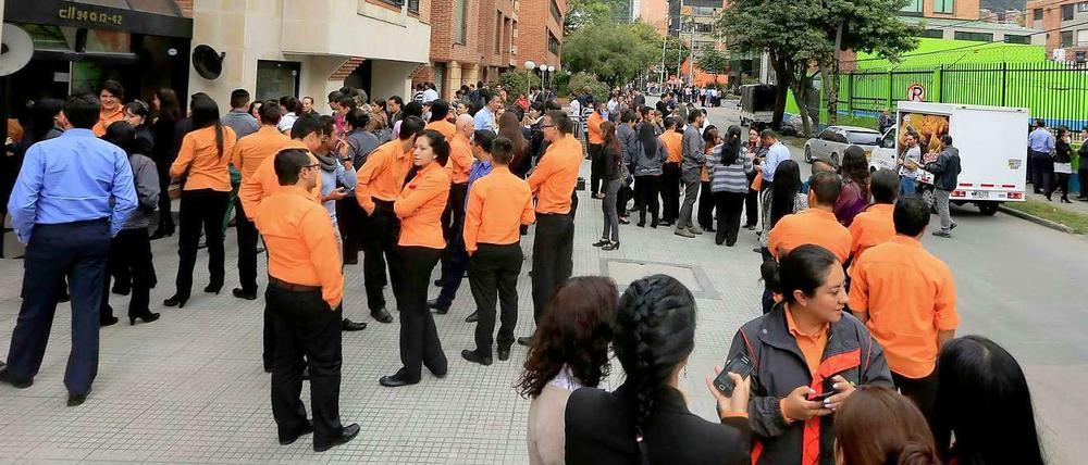 Menschen in Bogotá warten vor einem Gebäude. Ein Erdbeben hat Kolumbien erschüttert.