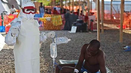 Ein an Ebola Erkrankter und ein Arzt in Sierra Leone. 
