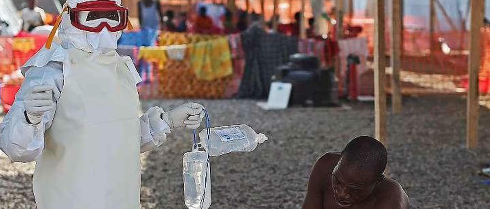 Ein an Ebola Erkrankter und ein Arzt in Sierra Leone. 