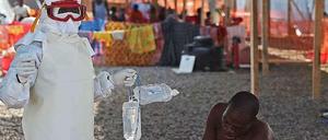 Ein an Ebola Erkrankter und ein Arzt in Sierra Leone. 