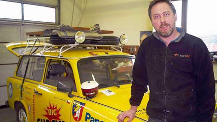 Der tschechische Abenteurer Dan Priban in seiner Werkstatt in Prag neben seinem für die "Transtrabant"-Expedition zurechtgemachten Trabant.