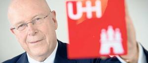 Dieter Lenzen, Präsident der Uni Hamburg, hält das Universitätslogo in die Kamera.