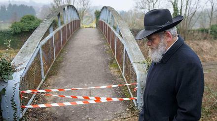 Ein Mann steht vor dem gesperrten Zugang zum jüdischen Friedhof in Sarre-Union in Frankreich, auf dem mehr als hundert Gräber geschändet worden waren. 