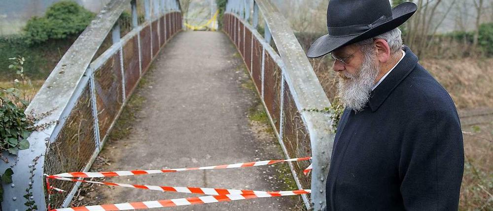 Ein Mann steht vor dem gesperrten Zugang zum jüdischen Friedhof in Sarre-Union in Frankreich, auf dem mehr als hundert Gräber geschändet worden waren.