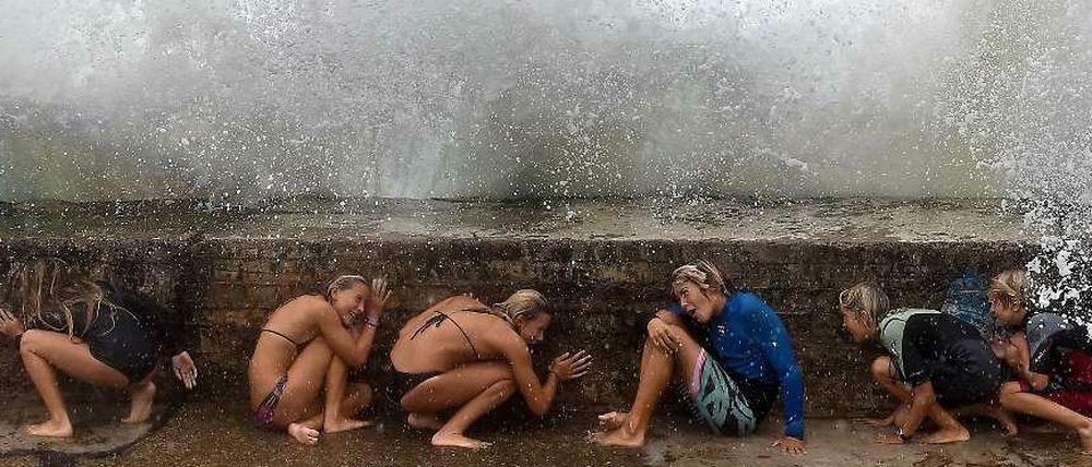 Kinder in Australien schützen sich vor einer Welle in Queensland, Australien. Der Wirbelsturm "Marcia" ist zu Besuch. 