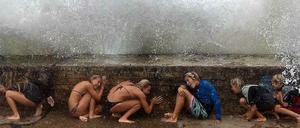 Kinder in Australien schützen sich vor einer Welle in Queensland, Australien. Der Wirbelsturm "Marcia" ist zu Besuch. 