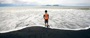 Todesstrand. Ein Kind steht am Wasser anlässlich der Trauerfeiern in Syiah Kuala in der indonesischen Provinz Aceh. Diese war vom verheerenden Tsunami vor zehn Jahren besonders betroffen.