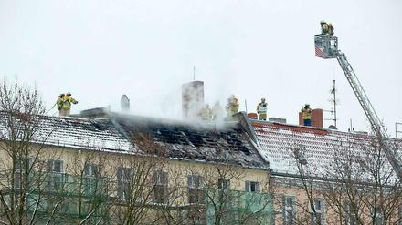 Alles unter Kontrolle: Feuerwehrleute löschen den Brand im Dachgeschoss eines Wohnhauses in Moabit.