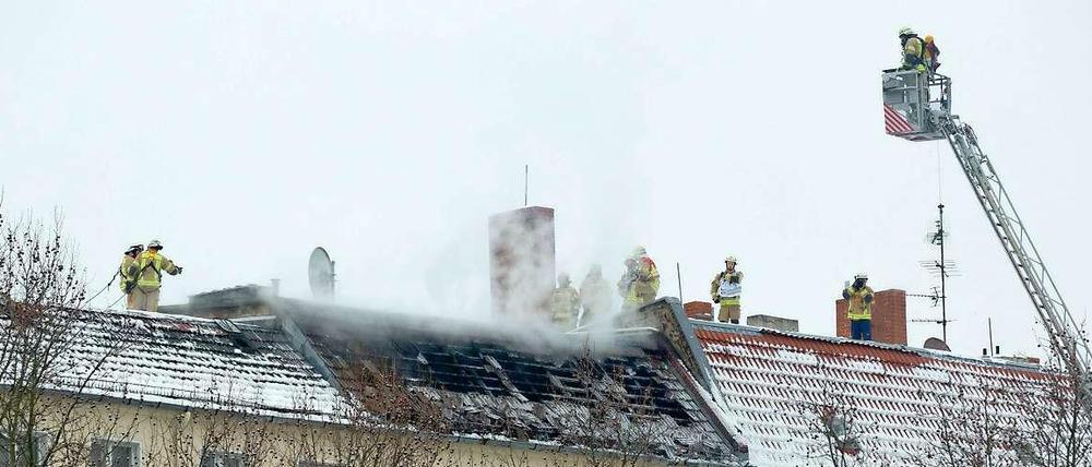 Alles unter Kontrolle: Feuerwehrleute löschen den Brand im Dachgeschoss eines Wohnhauses in Moabit.