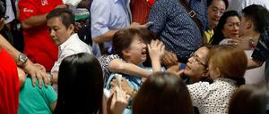 Schreie gellen durch die Hallen: Angehörige im Flughafen von Surabaya.