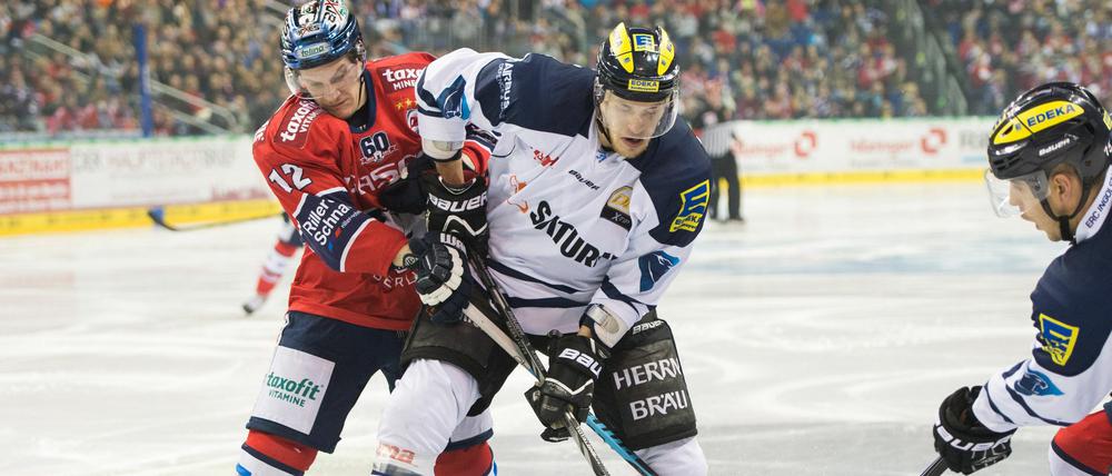 Berlins Laurin Braun (l) und Ingolstadts Benedikt Schopper (r) kämpfen um den Puck.