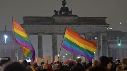 Gegendemonstranten vor dem dunklen Brandenburger Tor.