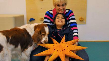 Ein fröhliches Trio. Physiotherapeutin Marion Jager und ihre Tochter Larissa zusammen mit Therapiehund Amy in Wilmersdorf.