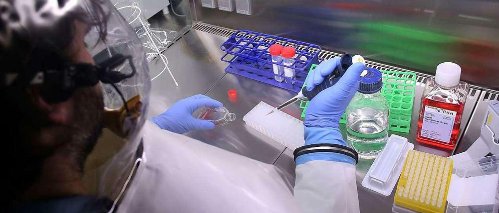 Eine Labormitarbeiterin hantiert mit Chemikalien.