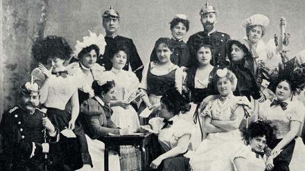 Eine bunt kostümierte Gesellschaft von Dienstbotinnen, Köchinnen und Gendarmen stellen das Komitee des Gesindeballs im Jahr 1898 in Berlin.