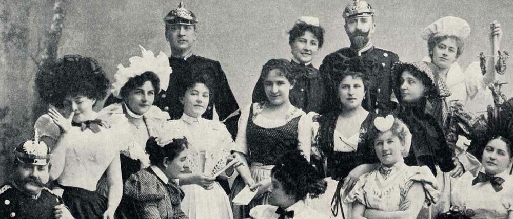 Eine bunt kostümierte Gesellschaft von Dienstbotinnen, Köchinnen und Gendarmen stellen das Komitee des Gesindeballs im Jahr 1898 in Berlin.