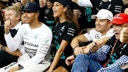 Höchststrafe. Hamilton wird gefeiert, Rosberg (r.) muss mitmachen.