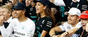 Höchststrafe. Hamilton wird gefeiert, Rosberg (r.) muss mitmachen.