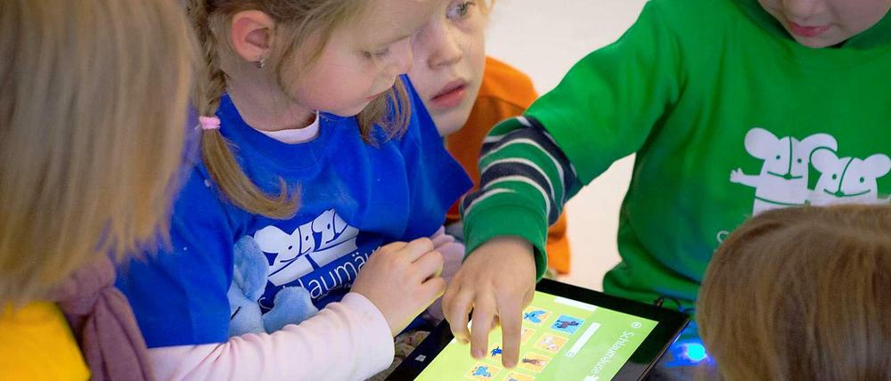 Kinder spielen mit einem Tablet-PC.