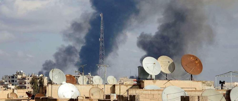 Über der syrischen Stadt Al-Rakka, einer Hochburg der IS-Extremisten, steigt Rauch auf. Sie soll von der syrischen Luftwaffe bombardiert worden sein.