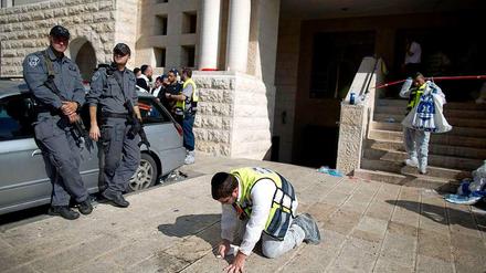 Nach dem Anschlag reinigt ein Mann den Boden vor der Synagoge.