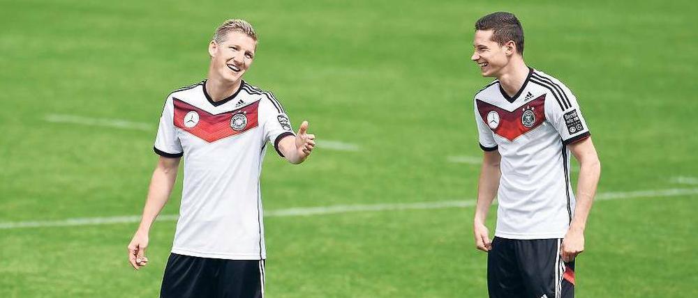 Ich bleib eh dabei, aber warum lachst du? Bastian Schweinsteiger (links) darf wohl trotz fraglicher Fitness mit zur WM fahren, Julian Draxler muss dagegen bangen.