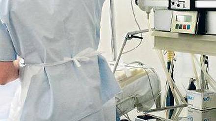 Ernstfall. Ein Arzt überwacht einen Patienten auf der Intensivstation. 