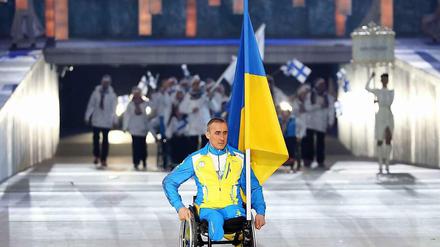Allein mit der Fahne: der ukrainische Athlet Michailo Tkatschenko bei der Eröffnungszeremonie der Paralympics 2014 in Sotschi.