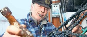 Sie haben Post – Flaschenpost. Der Kieler Berufsfischer Konrad Fischer hält seinen Ostseefund aus dem Jahr 1913 in der Hand. Der Brief sollte nach Berlin.