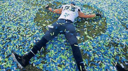 Baden in Vereinsfarben. Seattles Malcolm Smith schwimmt in Konfetti. Der Linebacker der Seahawks wurde zum wertvollsten Spieler der Partie gewählt.
