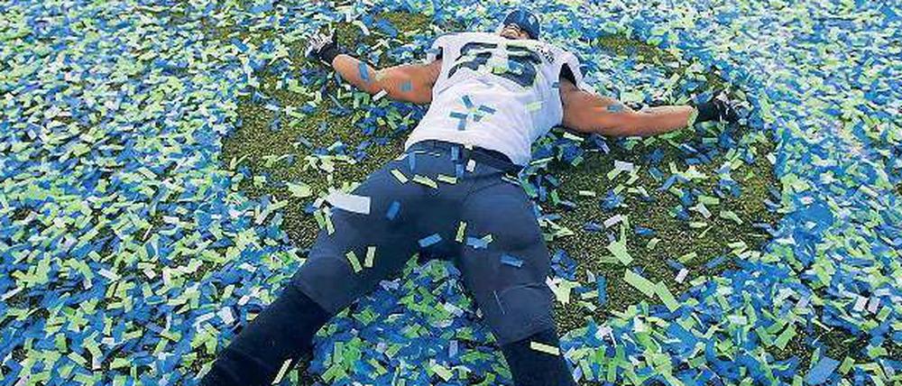 Baden in Vereinsfarben. Seattles Malcolm Smith schwimmt in Konfetti. Der Linebacker der Seahawks wurde zum wertvollsten Spieler der Partie gewählt.