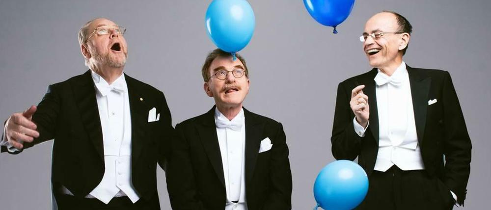 Drei Nobelpreisträger mit blauen Ballons.
