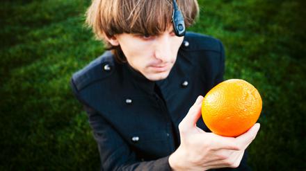 An seinem Hinterkopf trägt der farbenblinde Neil Harbisson einen Chip, heraus ragt eine schwarze Antenne mit einem optischen Sensor, der die Farben einfängt. Beispielsweise die einer Orange.