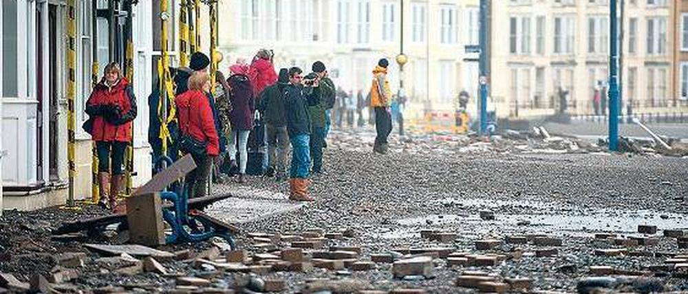 Mit Ziegeln und Unrat sind die Uferstraßen der walisischen Küstenstadt Aberystwyth übersäht, nachdem Sturmfluten über den Ort hereingebrochen waren.