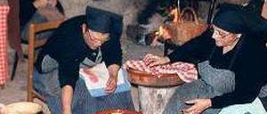 In Ruinen kochen Frauen über offenem Feuer für das Weihnachtsfest. 