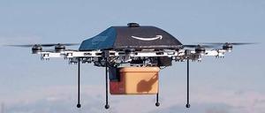 Zustellung ohne Bote. Für Amazon liegt die Zukunft der Logistik in der Luft. Der „Octocopter“, so genannt wegen der acht Motoren, trägt das Logo des Konzerns. Der geschwungene Pfeil soll ein Lächeln symbolisieren. Unten hängt eine gelbe Box für die bestellte Ware. Foto: dpa