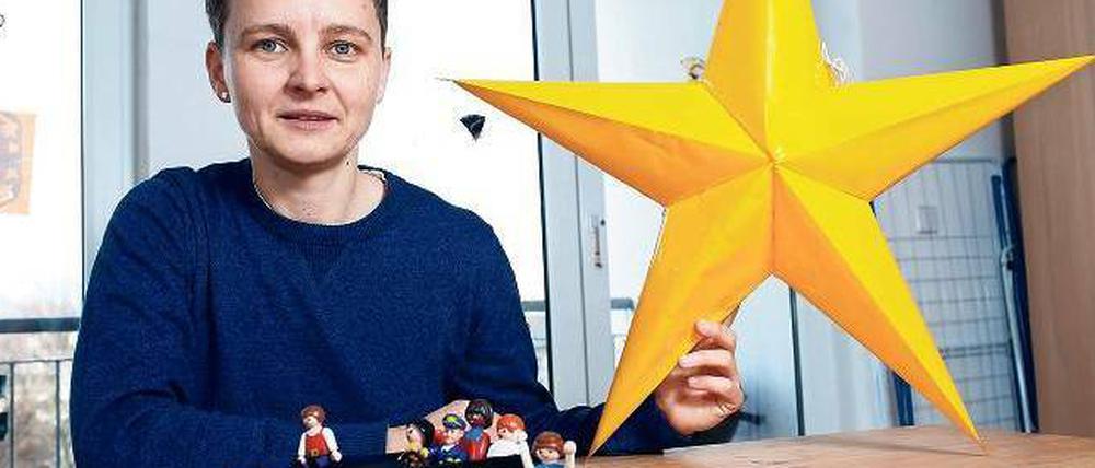 Auf Tour. Die Kinder, die in den Wohngruppen von „neuhland“ leben, sind schwer traumatisiert. Leiterin Katja Zimmermann hält hier den Tagesspiegel-Spendenstern - und hat eine Ausflugssituation mit Spielzeug nachgestellt.
