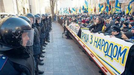 Klare Fronten: Vor dem schwer bewachten Parlament in Kiew forderten Demonstranten die Absetzung der Regierung. „Das Parlament ist auf der Seite des Volkes“, steht auf dem Plakat. Doch die ukrainische Regierung überstand das Misstrauensvotum. Foto: Alexey Furman/dpa