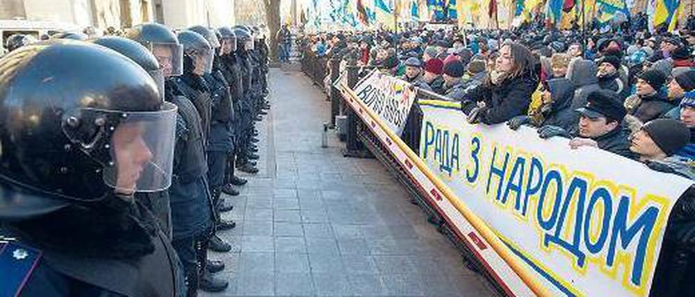 Klare Fronten: Vor dem schwer bewachten Parlament in Kiew forderten Demonstranten die Absetzung der Regierung. „Das Parlament ist auf der Seite des Volkes“, steht auf dem Plakat. Doch die ukrainische Regierung überstand das Misstrauensvotum. Foto: Alexey Furman/dpa