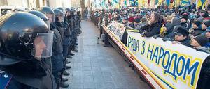 Klare Fronten: Vor dem schwer bewachten Parlament in Kiew forderten Demonstranten die Absetzung der Regierung. „Das Parlament ist auf der Seite des Volkes“, steht auf dem Plakat. Doch die ukrainische Regierung überstand das Misstrauensvotum. Foto: Alexey Furman/dpa