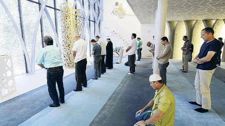 Muslimische Männer stehen in einer Moschee in Bayern.