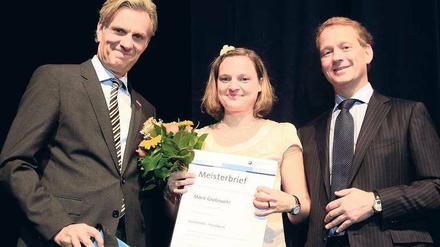 Glückwunsch! Die Handwerkskammer- und IHK-Präsidenten Stephan Schwarz (li.) und Eric Schweitzer gratulieren Buchbinder-Meisterin Marie Grotewohl. Foto: Davids/S. Darmer
