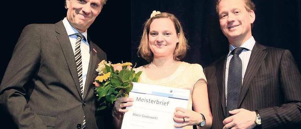 Glückwunsch! Die Handwerkskammer- und IHK-Präsidenten Stephan Schwarz (li.) und Eric Schweitzer gratulieren Buchbinder-Meisterin Marie Grotewohl. Foto: Davids/S. Darmer