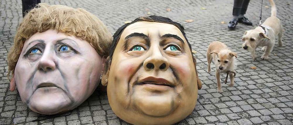 Masken von Angela Merkel und Sigmar Gabriel vor dem Bundestag bei einer Protestaktion.